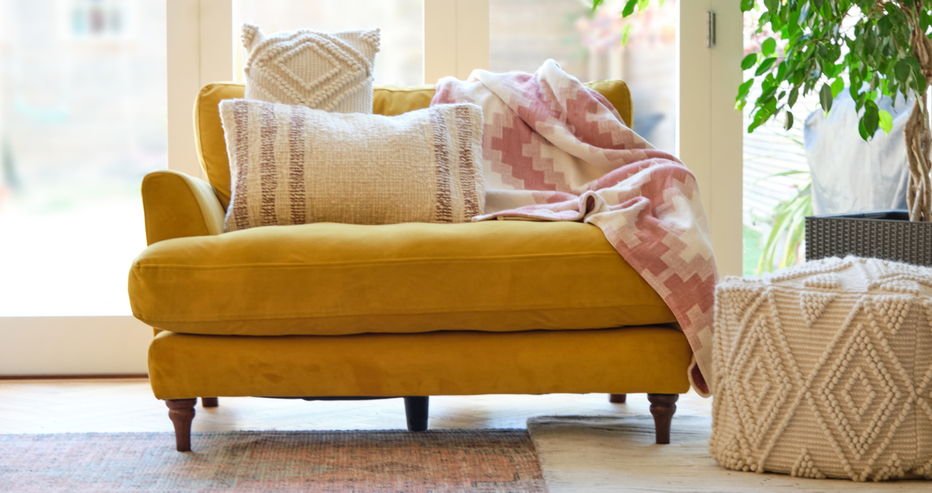 Cosy image of light and bright living space with stylish footstool and matching cushions