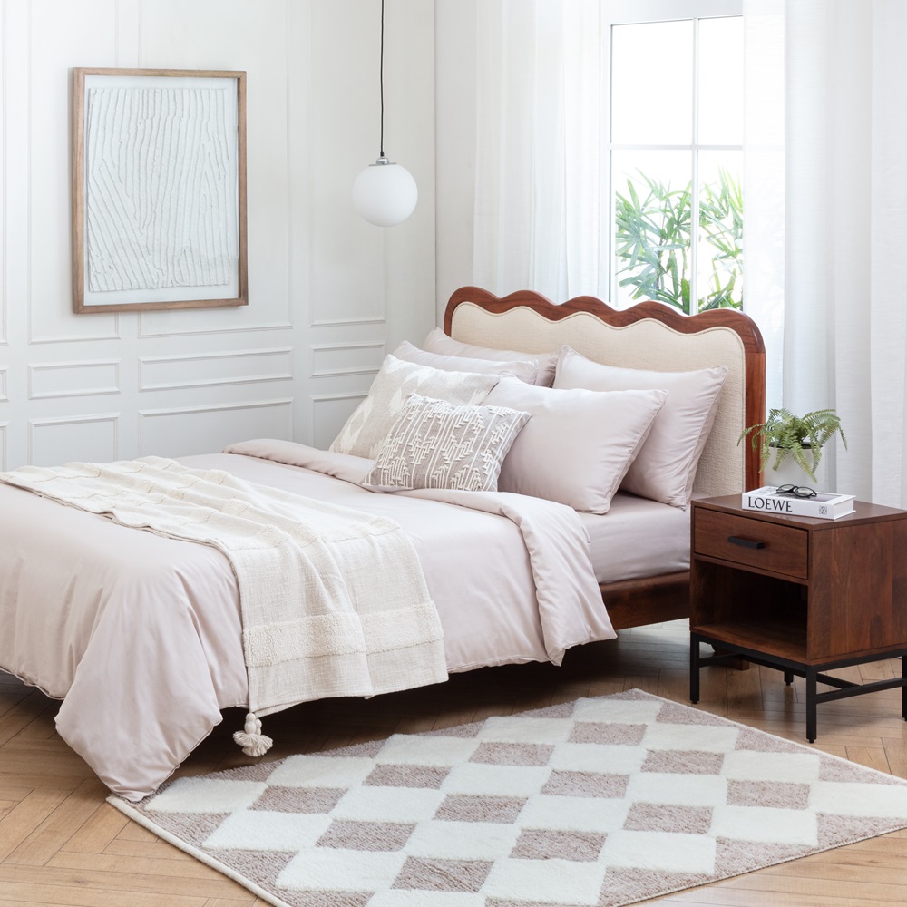 A bedroom with a rug and wall art