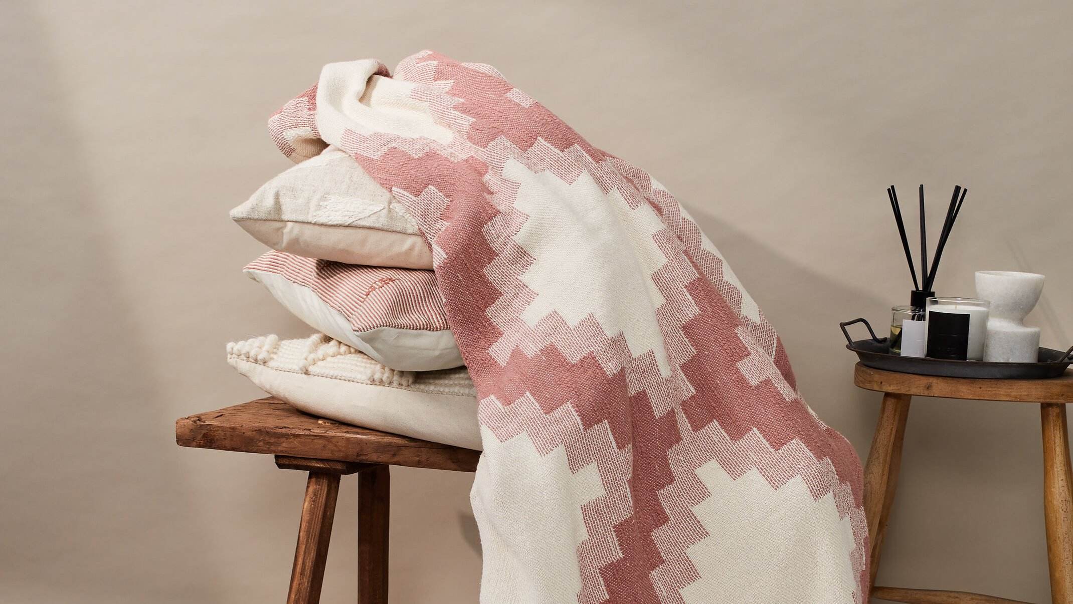 A geometric throw draped over a pile of cushions