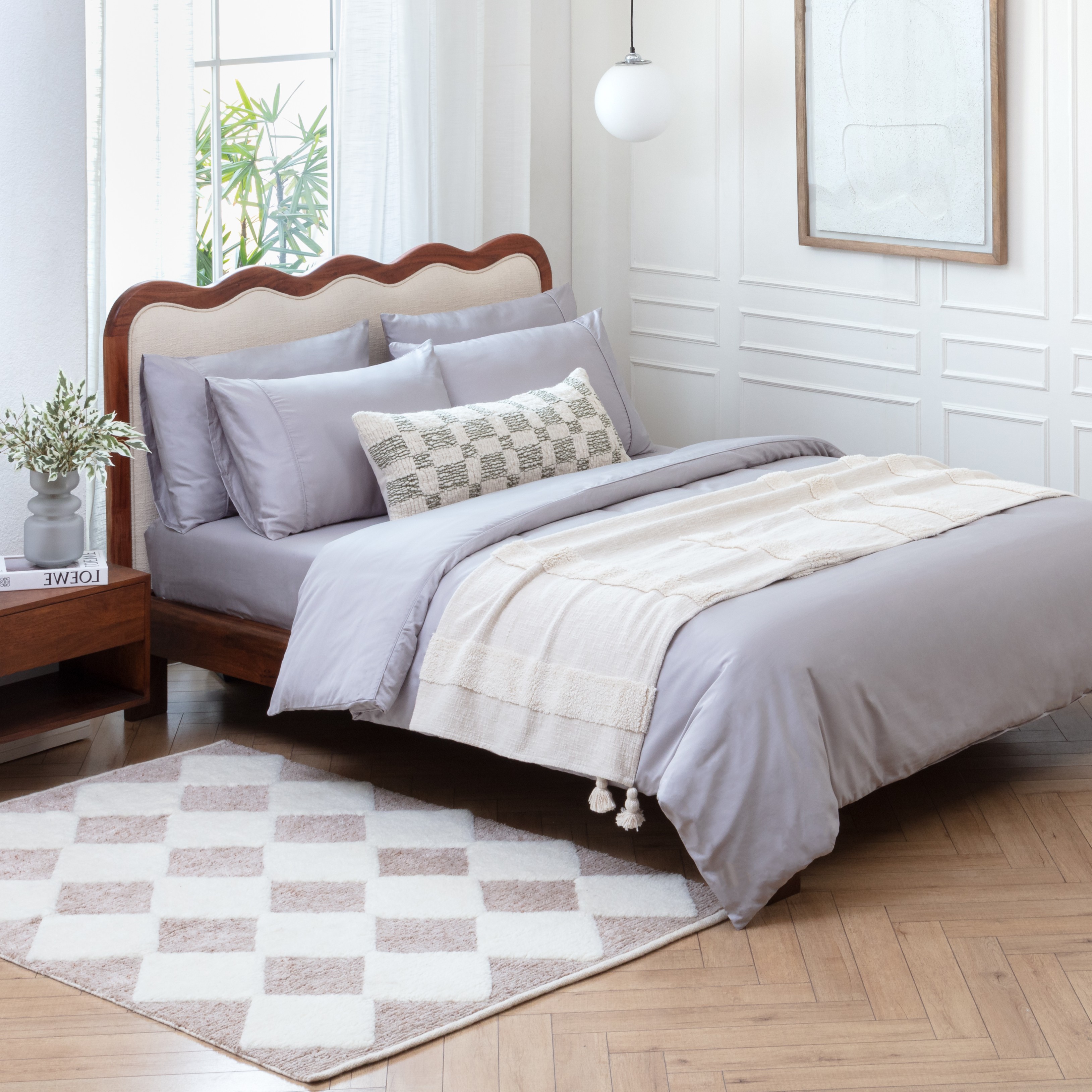 A checkered wool rug and a throw decorating a grey cotton duvet set