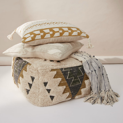 a woven patterened footstool with matching cushions