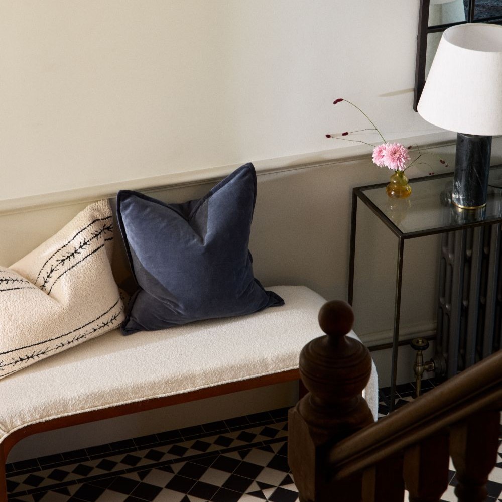 A wooden chair with a mustard geometric cushion