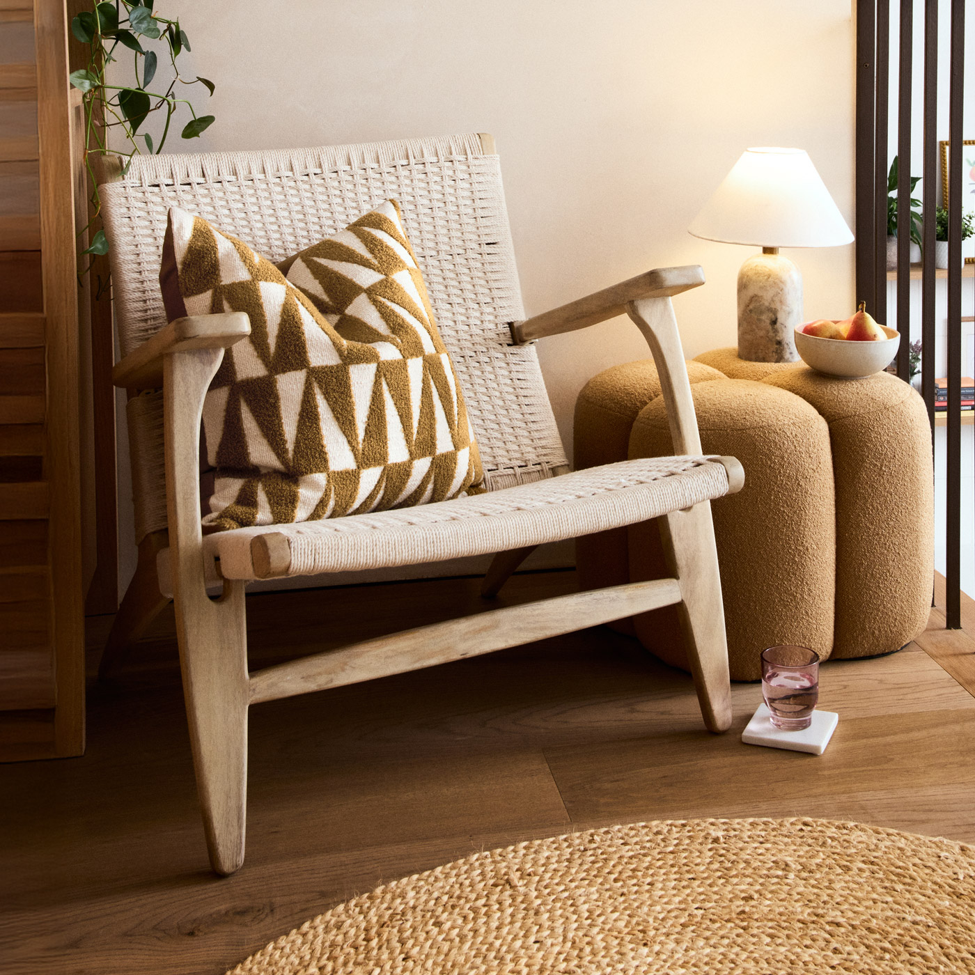 A Cucumber and Rose candle on a side table with flowers