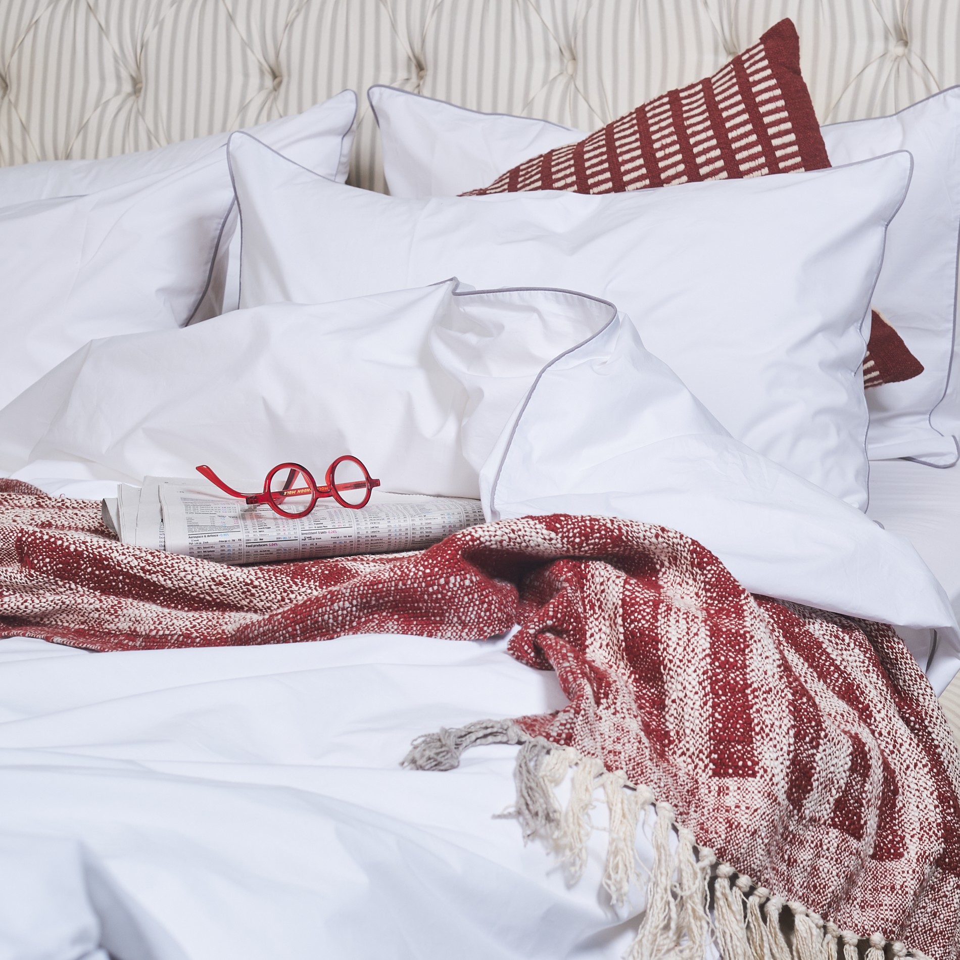 White high thread count cotton bed sheets with a jacquard rust red throw