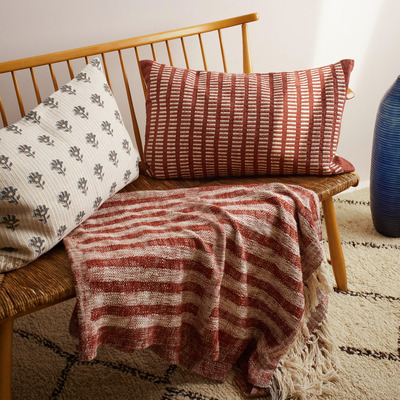 Luxury cushions on a woven chair with a matching throw