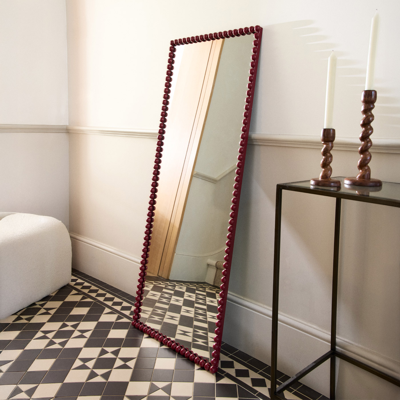 A white boucle bench with cushions in a living room