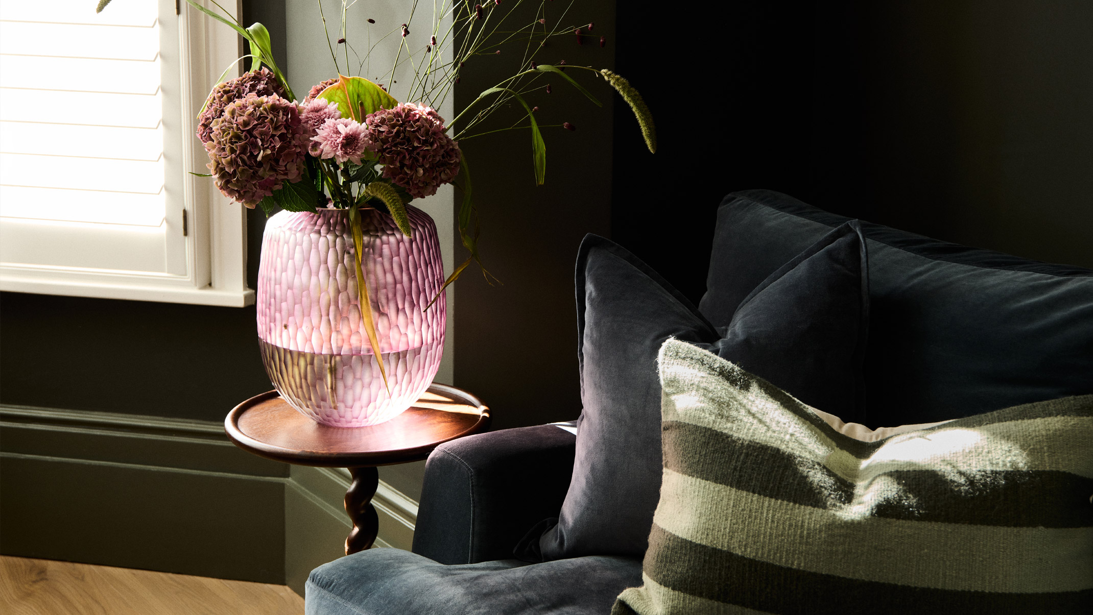 A geometric throw draped over a pile of cushions